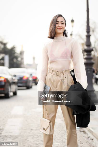 Guest wearing Chanel bag, organza top and beige paperbag pants outside the Chanel show during Paris Fashion Week Womenswear Fall/Winter 2020/2021 Day...