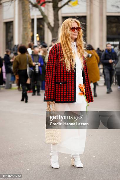 Blanca Miro wearing Miu Miu red and black check jacket, net bag, white socks, white wedge heels and white skirt outside the Miu Miu show during Paris...