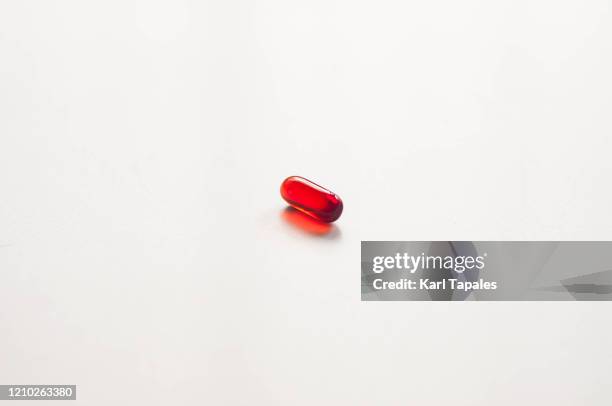 a red medicine gel capsule on a white background - red pill stock pictures, royalty-free photos & images