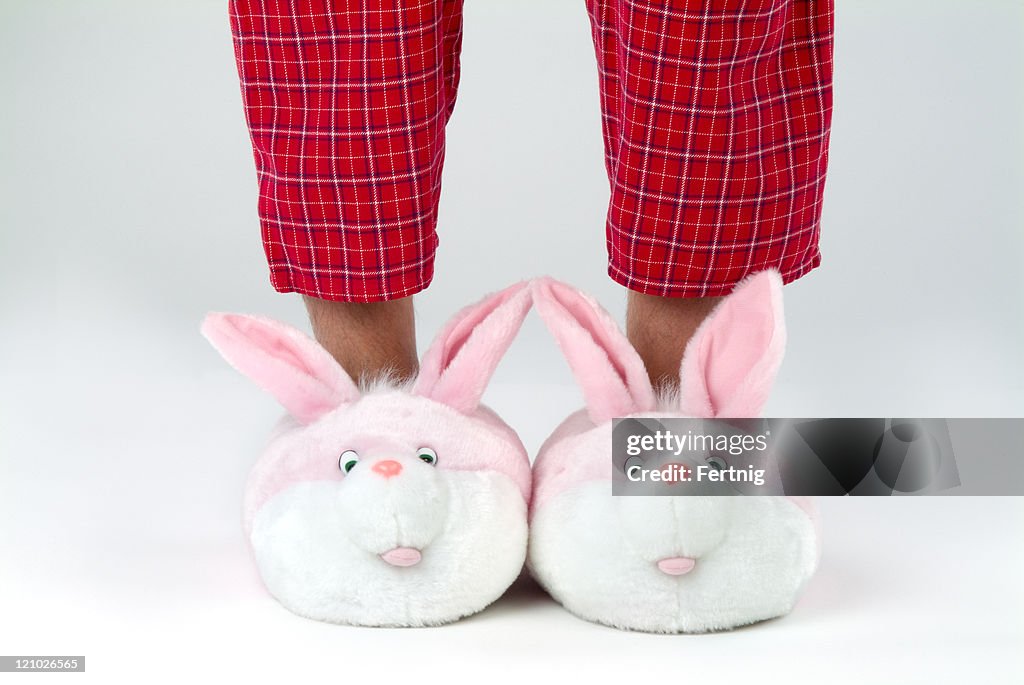 Man's legs in bunny slippers