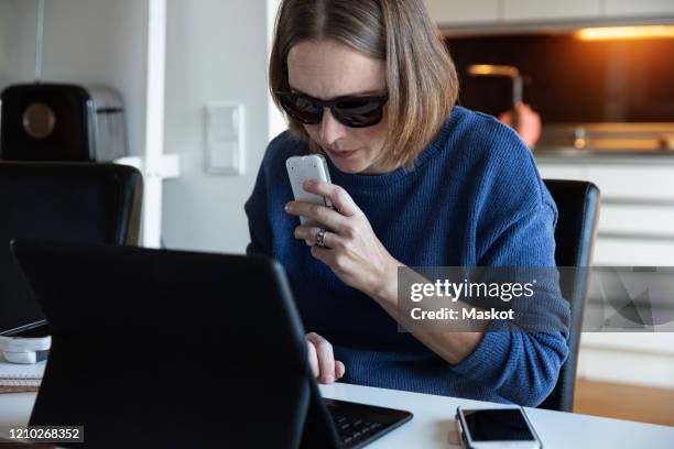 blind woman recording voice in recorder while using digital tablet at home - blind woman stock pictures, royalty-free photos & images