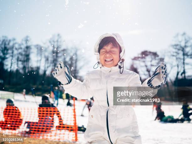 happy baby boy throwing snow. - japan skiing stock pictures, royalty-free photos & images