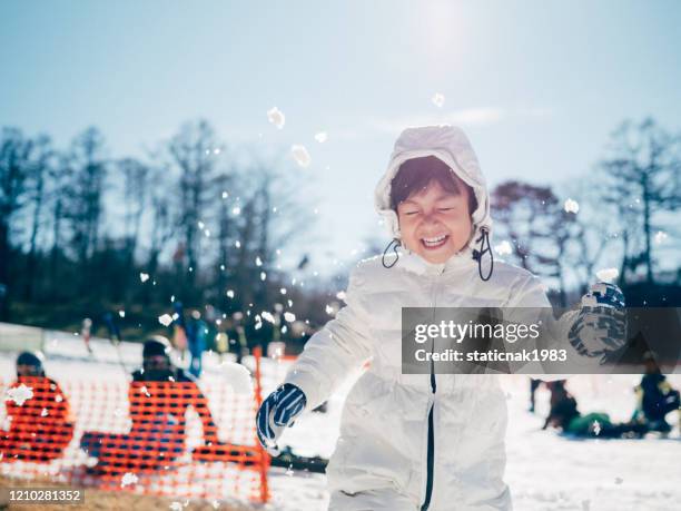 happy baby boy throwing snow. - japan skiing stock pictures, royalty-free photos & images