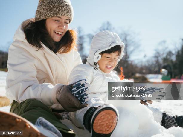 family building a snowman - winter woman showing stock pictures, royalty-free photos & images