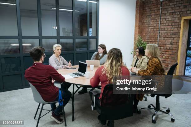 businesswoman in early 40s holding meeting with colleagues - round table discussion stock-fotos und bilder