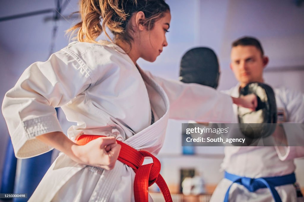 Jugadora de karate femenina practicando con entrenador