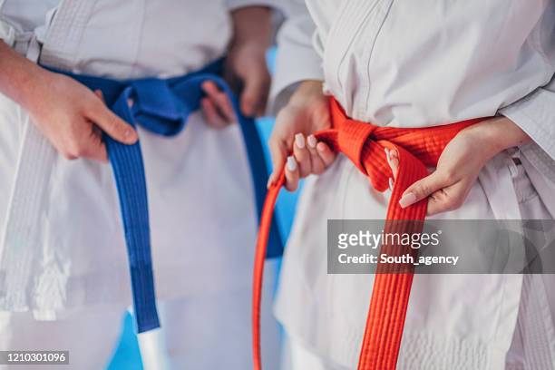 teenagers tying karate belt - cinto azul imagens e fotografias de stock