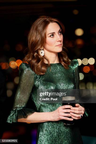 Catherine, Duchess of Cambridge holds a pint of Guinness as she visits the Guinness Storehouse’s Gravity Bar during day one of their visit to Ireland...