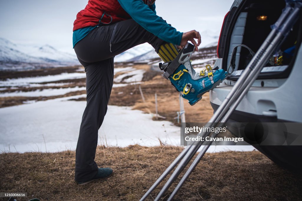 Woman putting on backcountry ski boot in Iceland