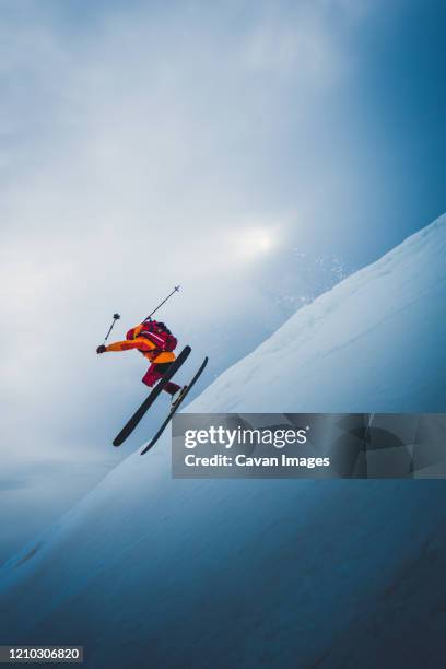 man flying off ski jump with sun and sky behind him - jump from helicopter stock pictures, royalty-free photos & images