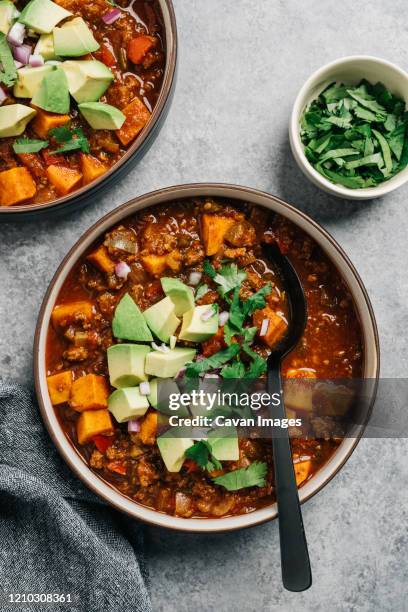 whole30 paleo chili con carne with sweet potato and fresh avocado - chili con carne stock pictures, royalty-free photos & images