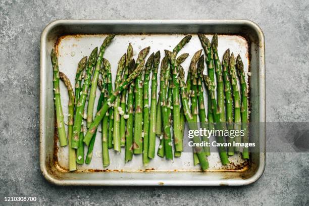 oiled asparagus on a baking sheet - cooked asparagus stock pictures, royalty-free photos & images