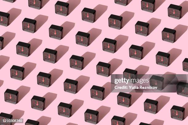 repeated black alarm clock on pink background - clock pattern photos et images de collection