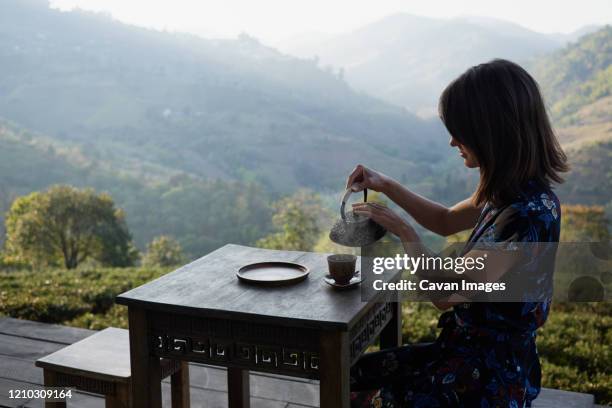 woman drinking tea in garden - japanese tea garden stock pictures, royalty-free photos & images