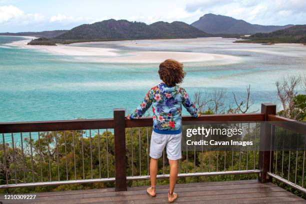 man at viewpoint looking at the ocean and sandbanks of the withsundays - airlie beach stock pictures, royalty-free photos & images