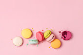 Mixed of colorful macaroni or pasta cake on a pink background. Sweet and colorful french macarons, pastel colors. Flat lay, top view. Add your text.