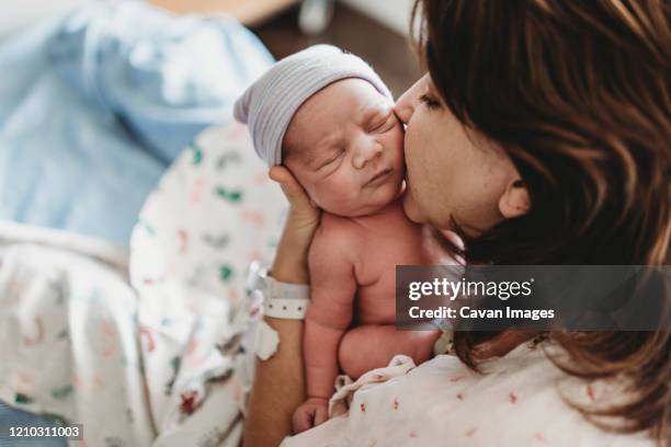 close up detail of mother kissing newborn son's cheek in hospital - new life 個照片及圖片檔