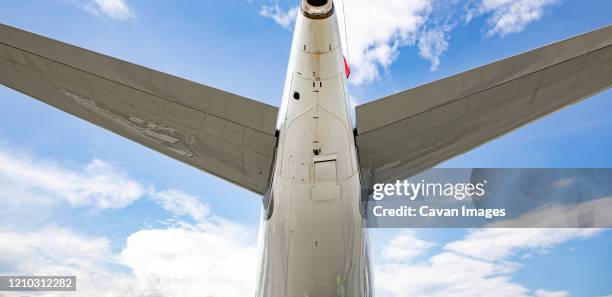 rear view of jet airliner showing auxiliary power unit - flapping wings stock pictures, royalty-free photos & images