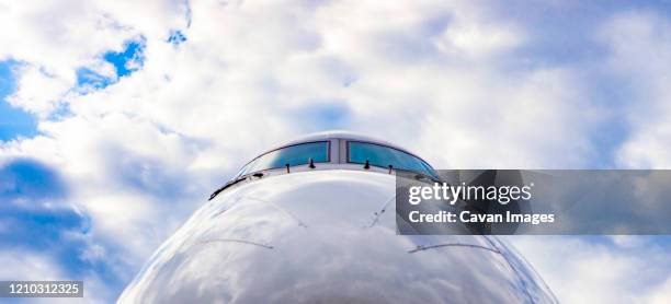 cockpit of jet airplane against blue cloudy skies - fuselage fotografías e imágenes de stock