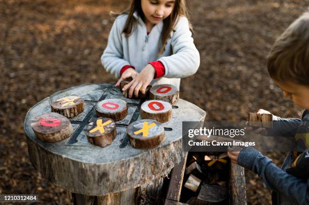 children playing tic tac toe at natural outdoor playground in texas - tic tac toe stock-fotos und bilder