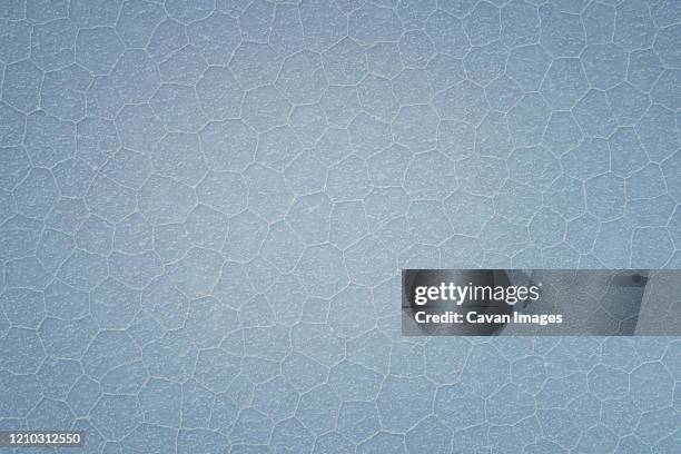 irregular poligonal estructures from aerial view in uyuni salar - cloud sales fotografías e imágenes de stock
