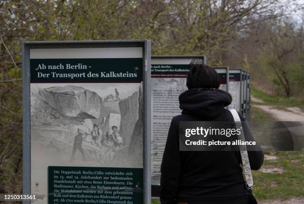 April 2020, Brandenburg, Rüdersdorf: A woman walks past information boards in the Rüdersdorf Museum Park. The 17ha large museum park offers stories...
