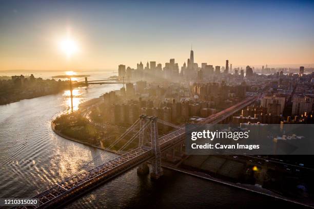 sunset over new york city and the williamsburg bridge, new york - williamsburg new york city stock-fotos und bilder