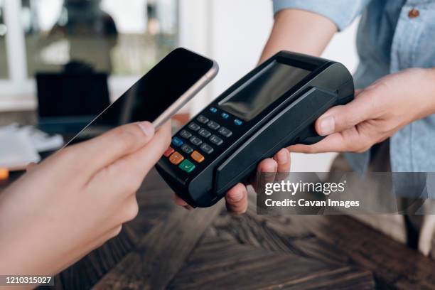paying bill through smartphone using nfc technology. - nfc payment stock-fotos und bilder