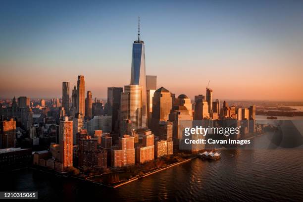 sunset over freedom tower and new york city's financial district. - world trade center photos et images de collection