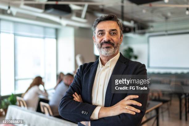 portrait of mature businessman at modern office - ceo imagens e fotografias de stock