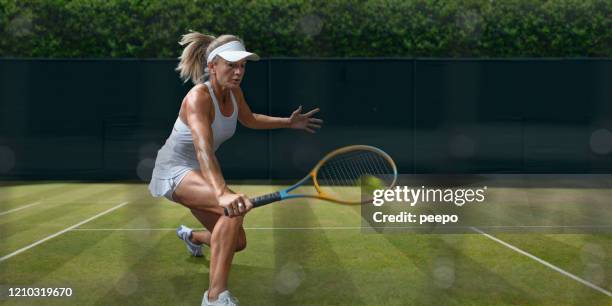 female tennis player in mid motion during grass court game - tennis grass stock pictures, royalty-free photos & images