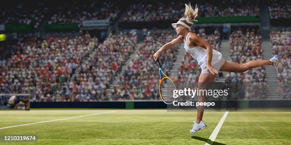 Tennista professionista che serve sul campo d'erba durante la partita Tennista professionista che serve sul campo d'erba durante la partita