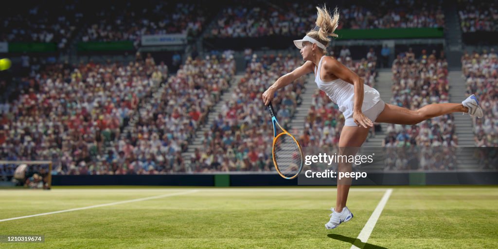 Professionell kvinnlig tennisspelare som tjänstgör på Grass Court under match