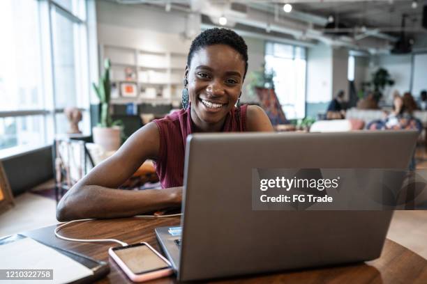 portret van jonge onderneemster die met laptop bij het coworking werkt - founders stockfoto's en -beelden