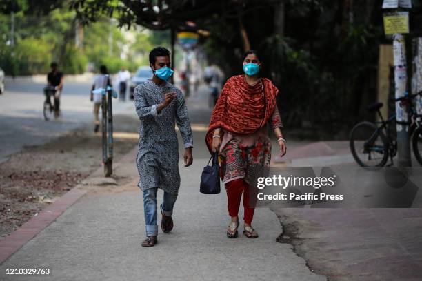 People are crossing road wearing face masks as a precautionary act to prevent CoVid-19 from being spread. With new 341 infected people in last 24...