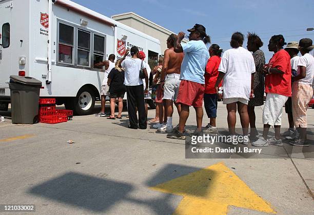 People line up for free meals provided by the Salvation Army on Friday, September 2, 2005 in Gulfport, Mississippi. President Bush toured this...