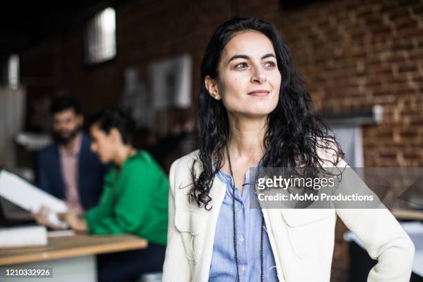 portrait of businesswoman in creative office - zelfvertrouwen stockfoto's en -beelden