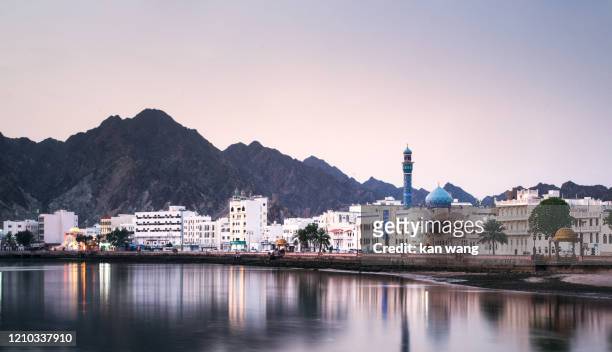 high angle view of buildings and mountains against sky - stock photo photo taken in muscat, oman - オマーン ストックフォトと画像