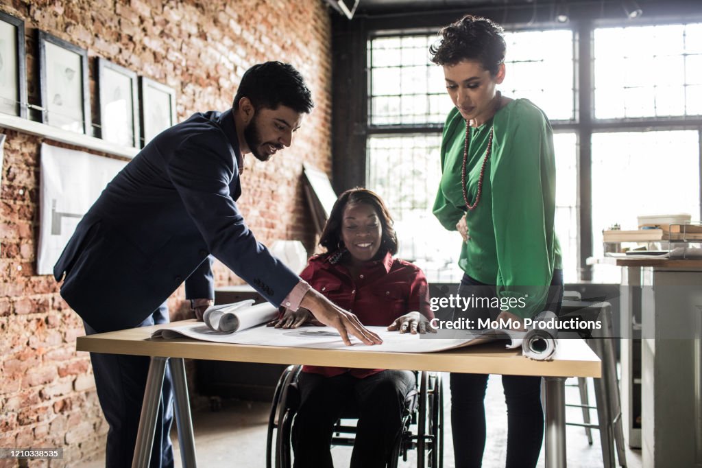 Business colleagues discussing architecture project in office