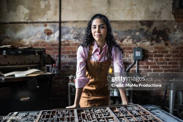 portrait of female business owner in printing shop - dreiviertelansicht stock-fotos und bilder