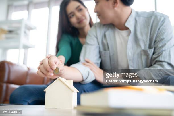 young couple saving money together - couple counting money stock pictures, royalty-free photos & images