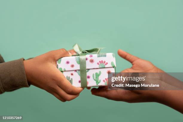 kids' hands giving and receiving a gift - child giving gift stock-fotos und bilder