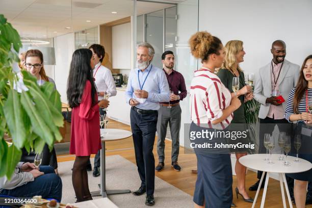zakenmensen socialiseren met champagne op kantoor evenement - entertainment evenement stockfoto's en -beelden