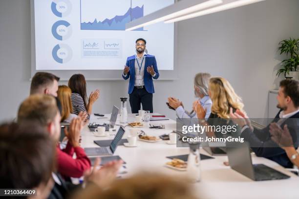 african businessman receiving applause for presentation - sales pitch stock pictures, royalty-free photos & images