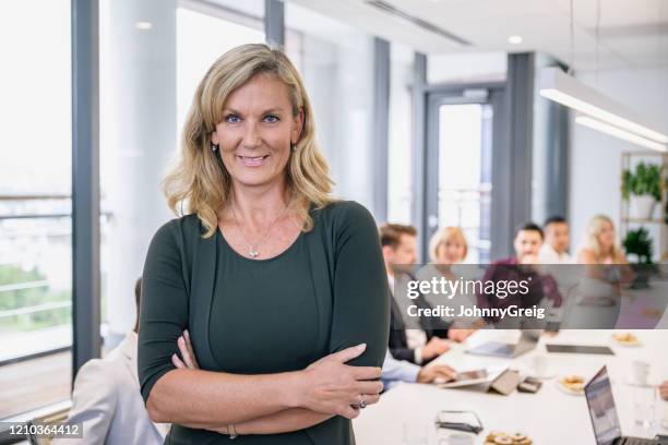 portret van rijpe vrouwelijke ceo in collectieve raadsruimte - mid volwassen mannen stockfoto's en -beelden