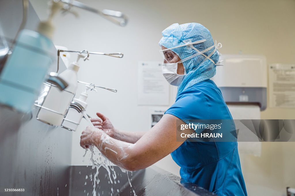 Nurse washing hands at medical facility to avoid Covid-19 virus.