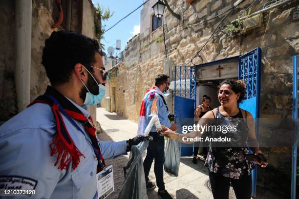 Group of people light candles of citizens who stayed at their houses, with the Holy Fire brought from the Church of the Holy Sepulchre in East...