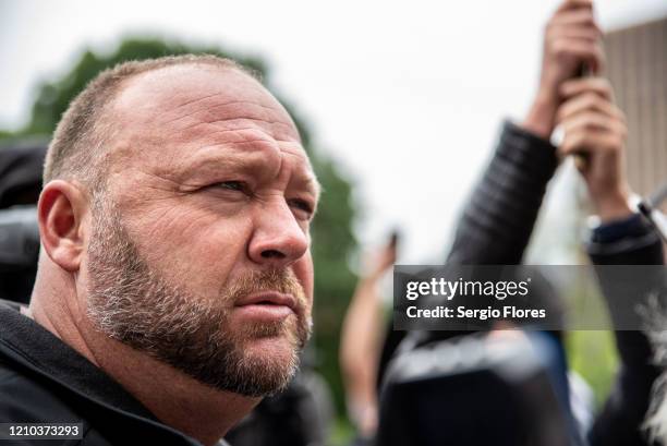 Infowars founder Alex Jones listens to a supporter at the Texas State Capital building on April 18, 2020 in Austin, Texas. The protest was organized...