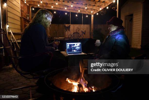 Neighbors sit around a fire-pit to watch Eddie Vedder perform during the "One World: Together at Home" concert in a backyard on April 18 in...