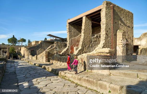 girls discover the palaestra in ancient ercolano (herculaneum) city ruins. naples, campania, italy - herculaneum stock pictures, royalty-free photos & images